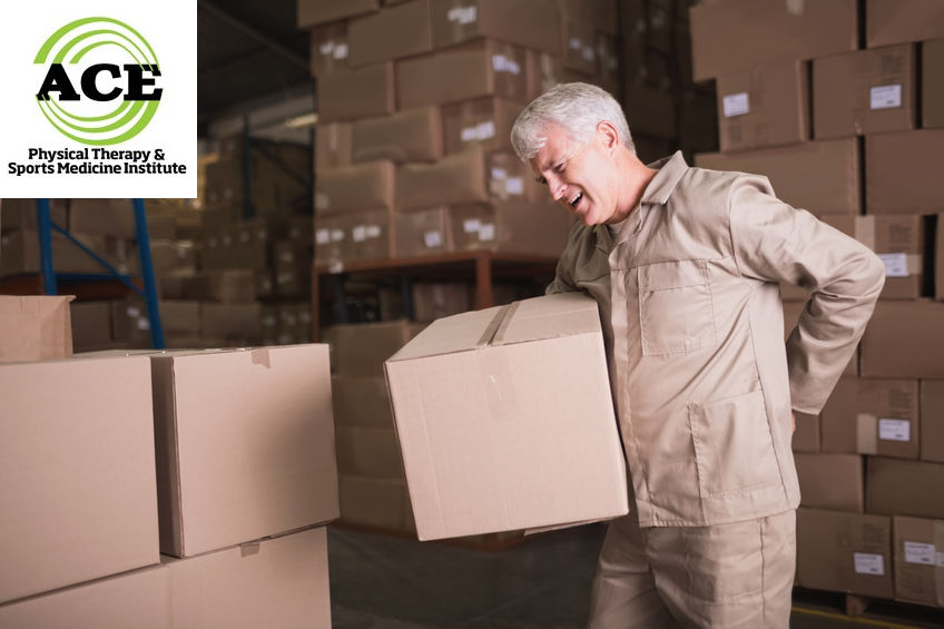 31909898 - side view of worker with backache while lifting box in the warehouse